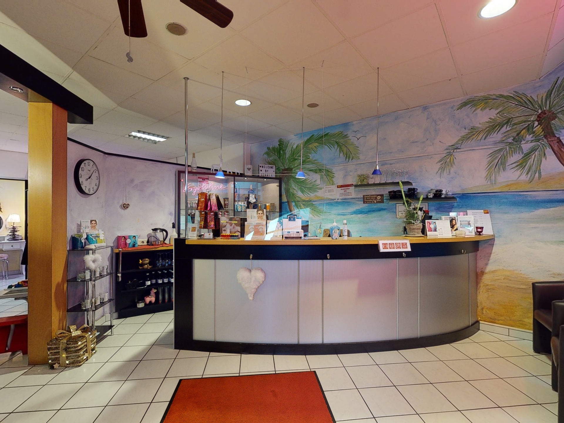Empfangsbereich von WELCOME SUN Schneider in Wörgl mit Theke und Strandmalerei